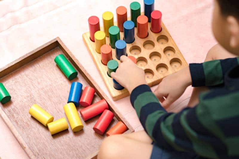 child learning math with wooden sensorial blocks