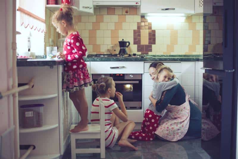Mother hugging child in the kitchen