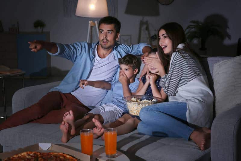 family watching TV on sofa at night