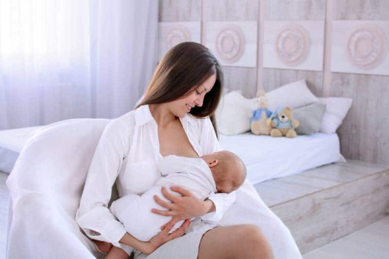 mother holding and nursing her newborn child