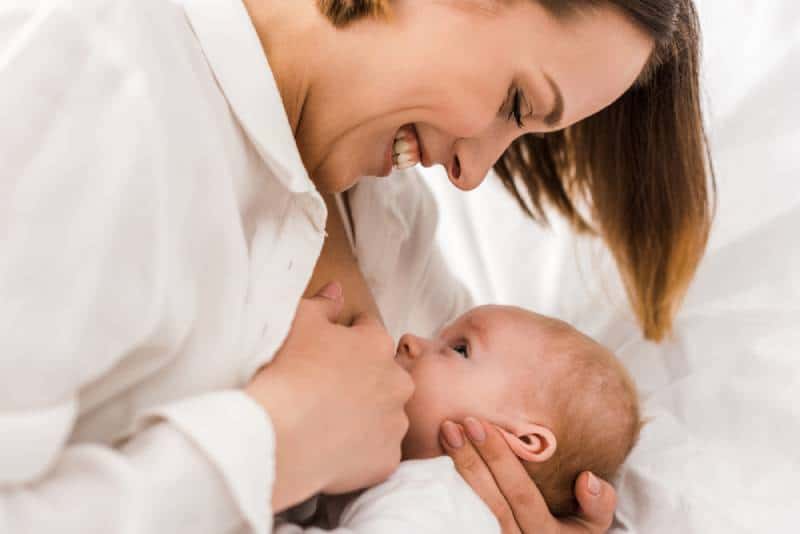 Hppy young mother nursing newborn baby