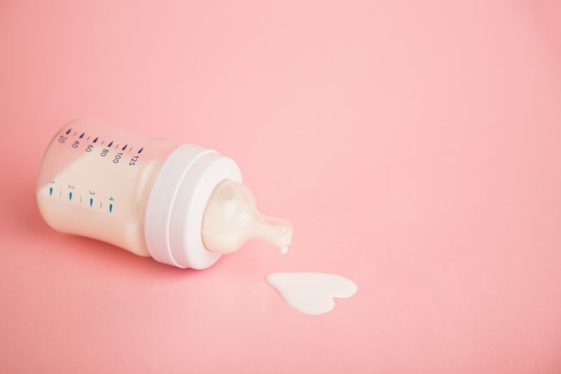 Breast milk in a bottle on a pink background