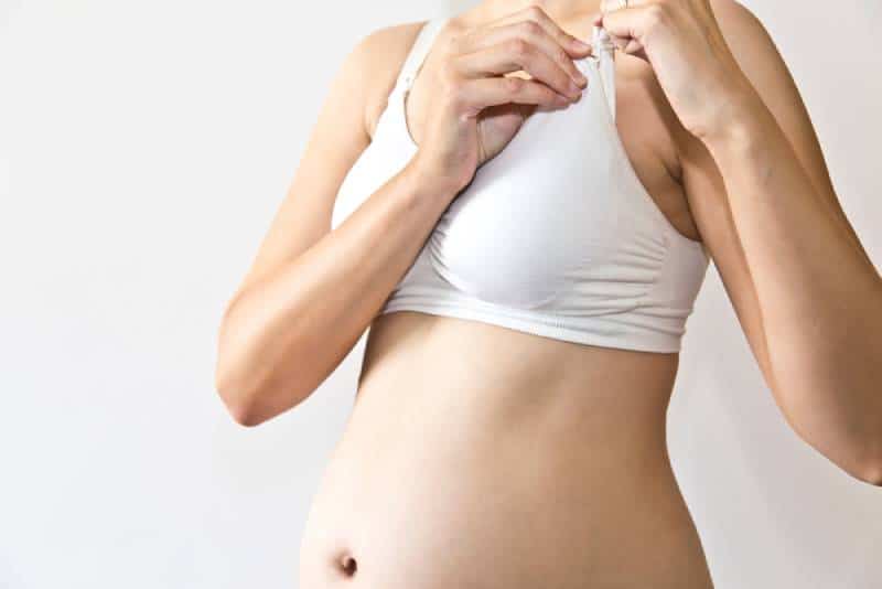pregnant woman closing bra