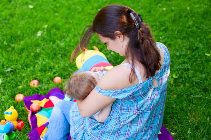 Woman breastfeeding child outside