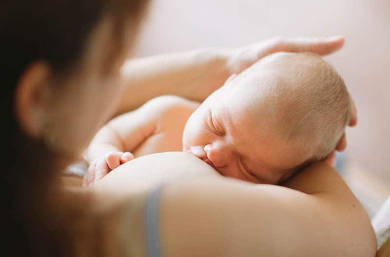 baby breastfeeding in his mother hands