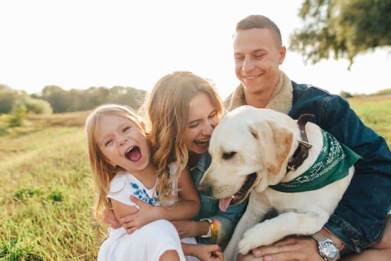 Mom, dad, and daughter with a dog