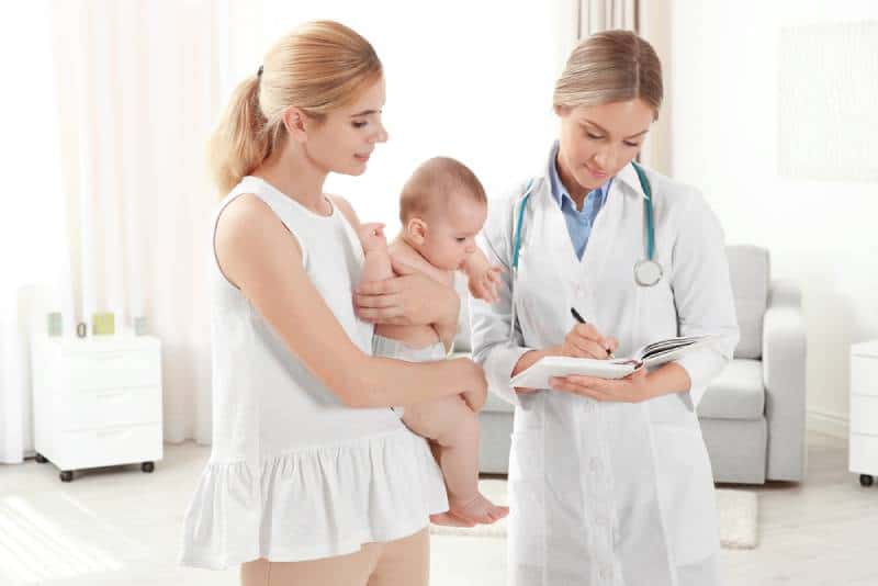 Pediatrician consulting mother with a baby