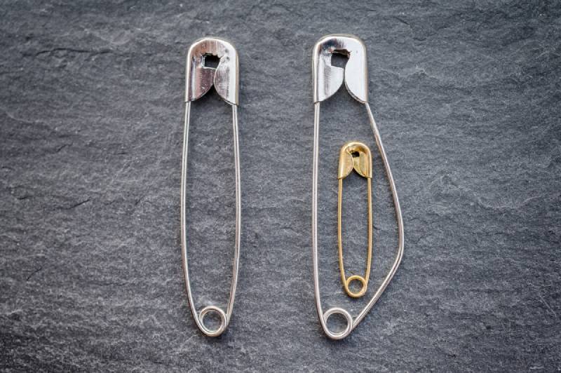 Pregnancy in a relationship depicted with safety pins