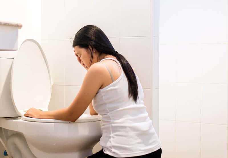 Pregnant woman feeling sick in bathroom