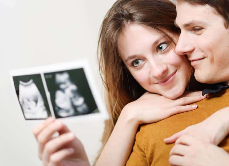 couple watching sonogram of their baby