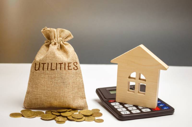 money bag with the word Utilities and a wooden house