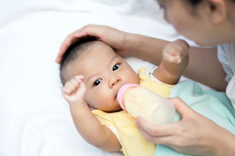 mother feeding baby with a milk bottle