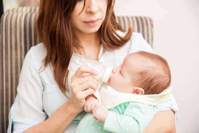 mother feeding her newborn baby from a bottle