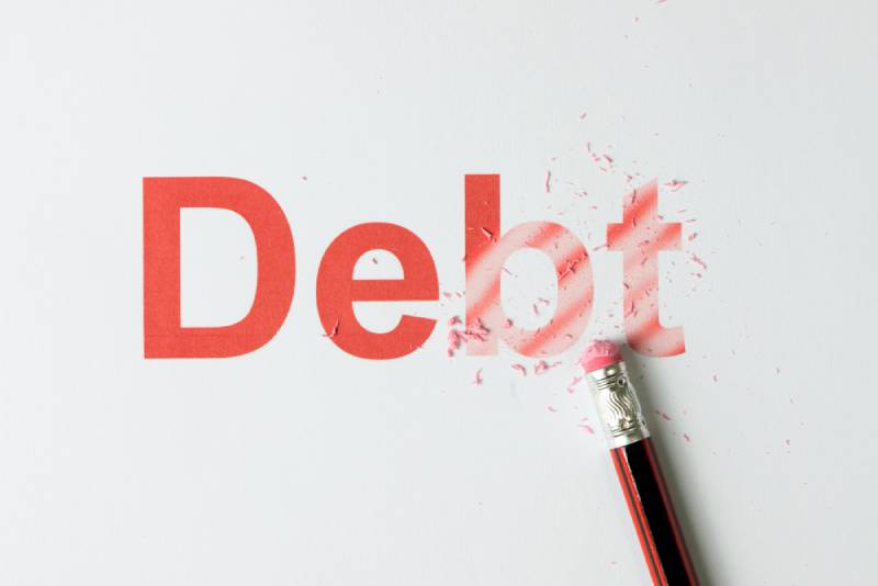 pencil erasing the word debt on paper