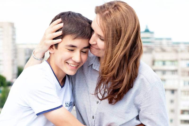 woman hugging her teenager son