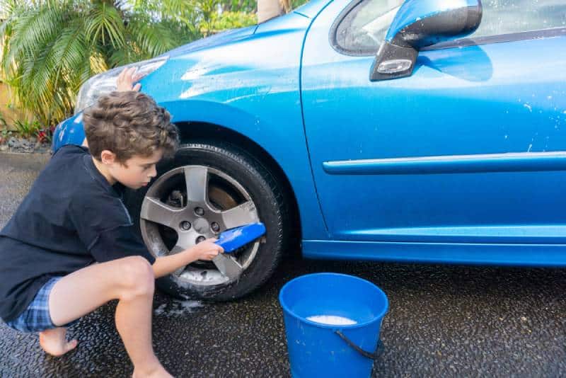 Boy earning pocket money - washing a car