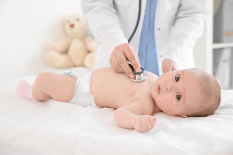 Doctor examining little baby boy