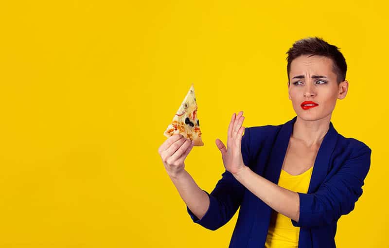 woman doesn't want to eat on yellow background