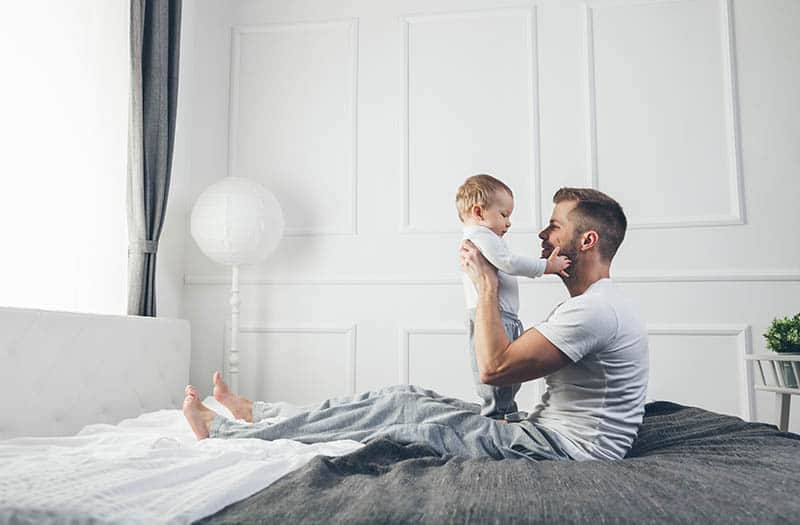baby and dad on bed