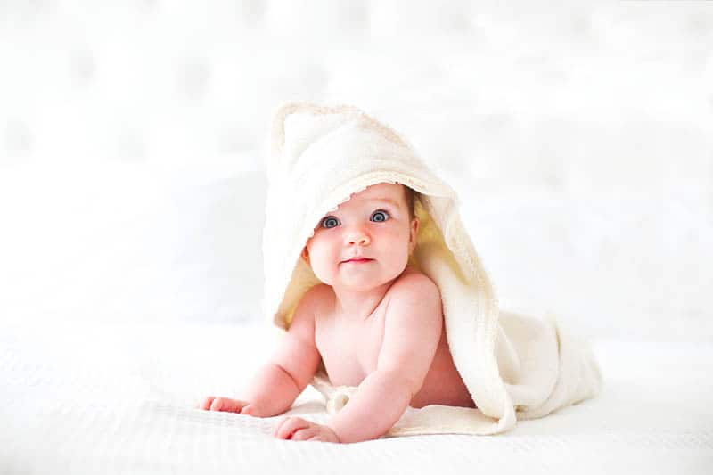 baby in yellow washcloths 
