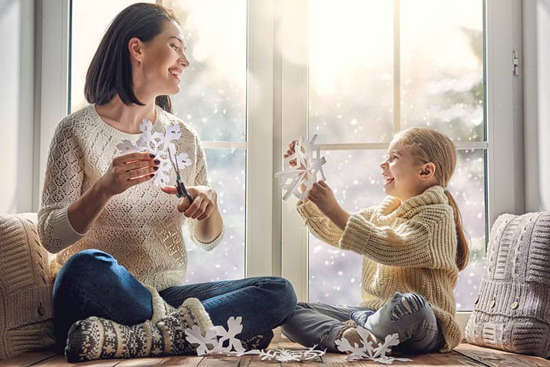 happy mom and girl making Christmas decorations 