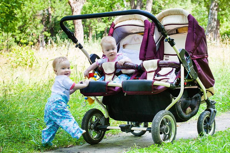 twin babies in lightweight double strollers