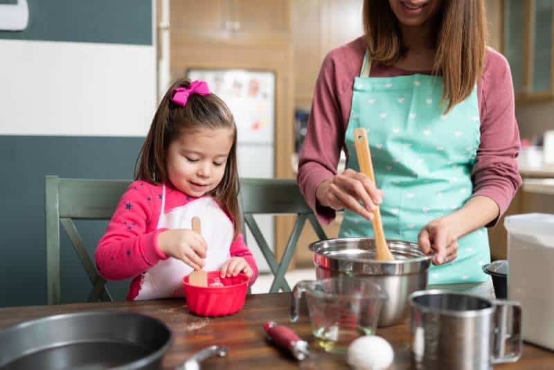 Little girl getting ready to bake some cookies with her mom 
