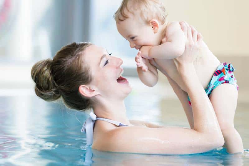 Mom with a child at the swimming class at pool