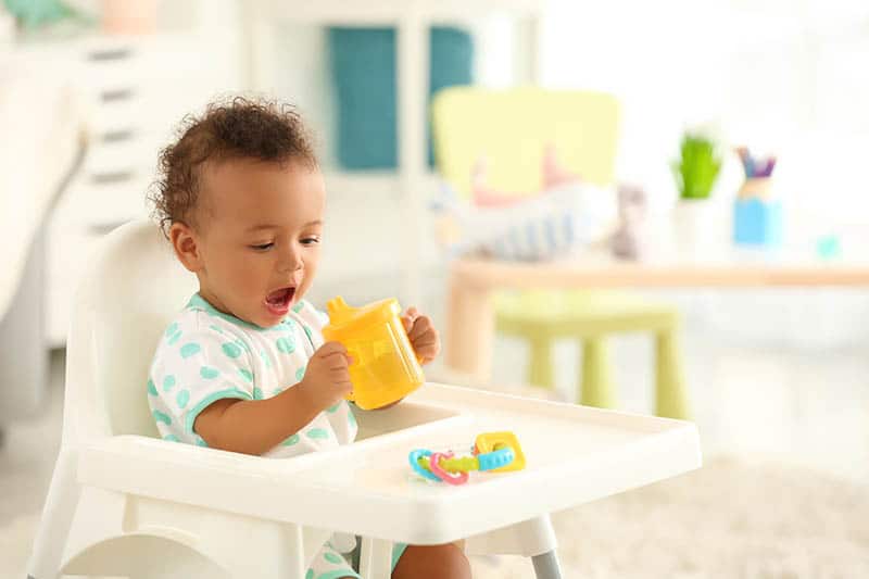 baby playing and eating in high chair