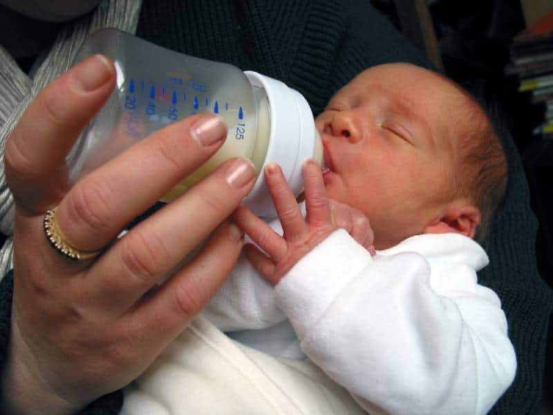 premature baby getting milk from a bottle in a hospital