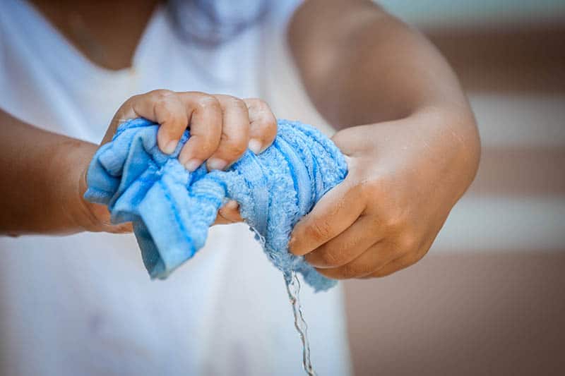 woman squeezing a towel 