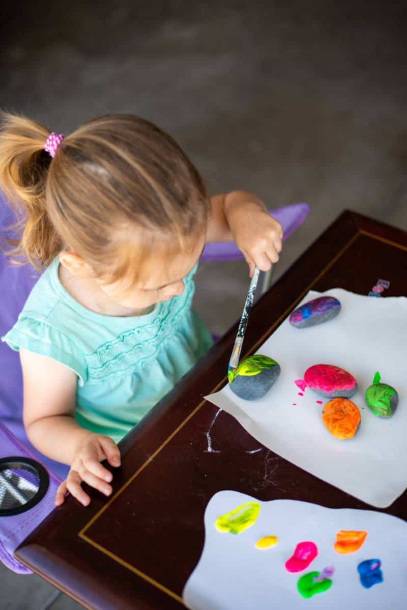 Toddler painting rocks at home