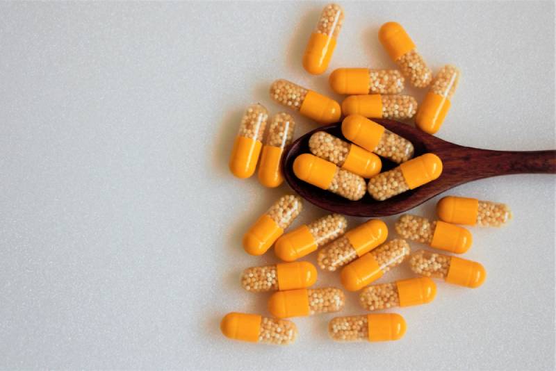 vitamin c plus zinc in yellow capsules on white background 