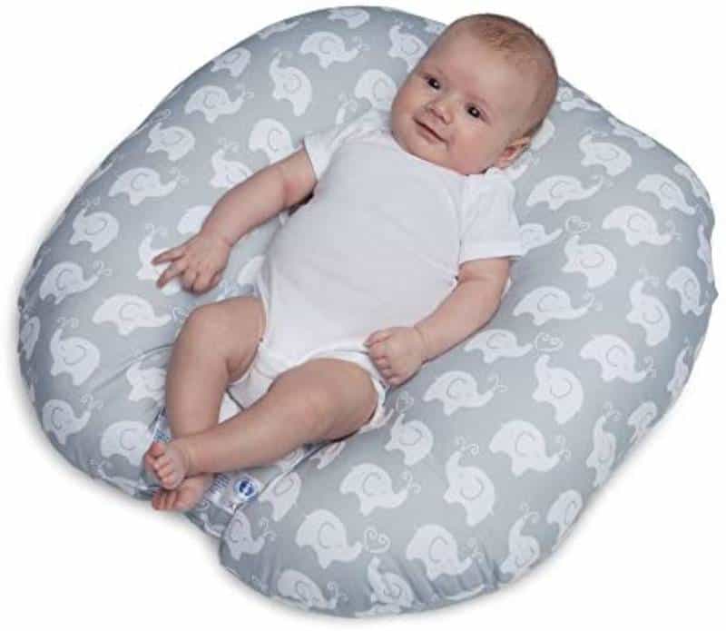 Baby in a white-gray baby lounger on a white background