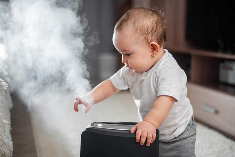 baby with black humidifier 