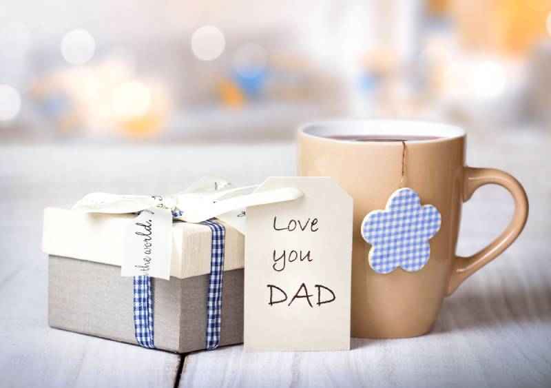 Father's day holiday greeting card with a mug on a wooden table