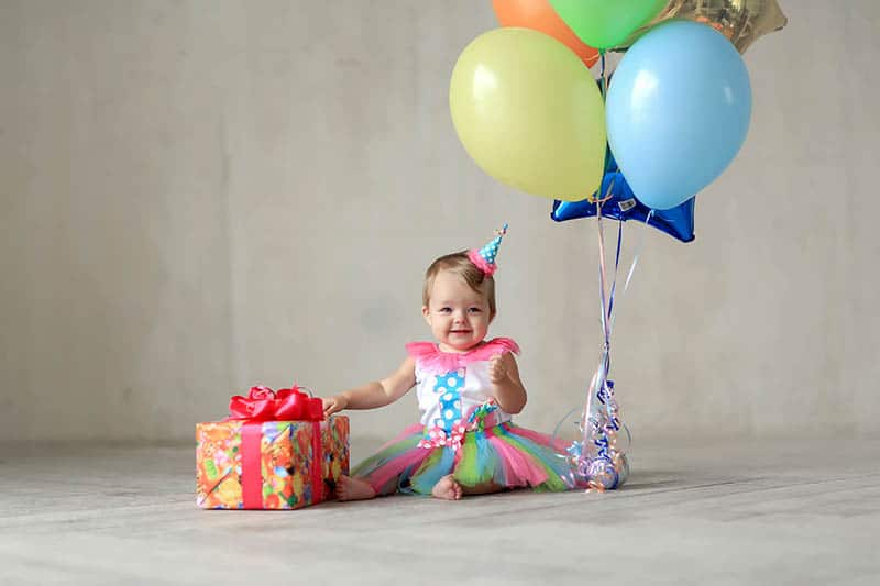 baby girl celebrating first birthday with gift