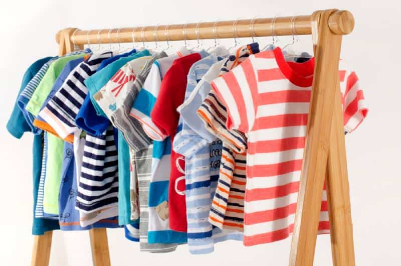 Dressing closet with colorful wardrobe of newborn kids, toddlers, babies full of all clothes