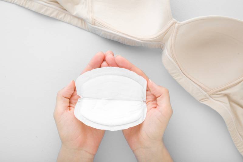 Woman holding a breast pad with both hands