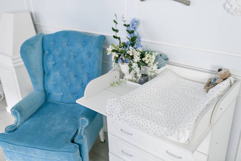 Blue chair and changing table for infants in a room
