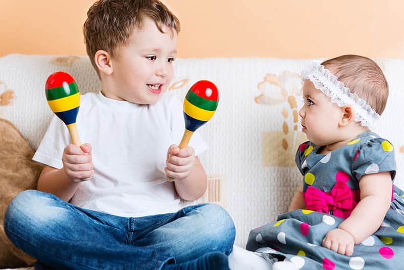 baby toddler siblings playing with musical instruments
