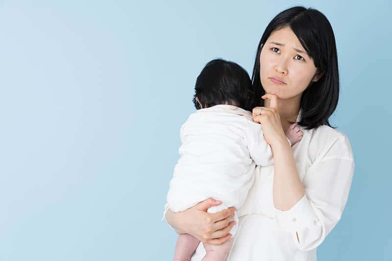 worried mom holding her baby, both in white on blue background