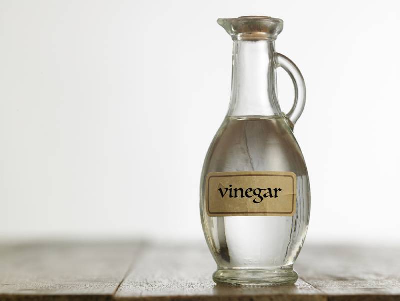 Bottle of white vinegar on the wooden table top