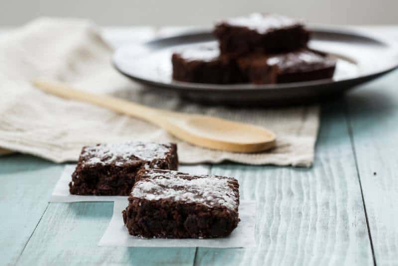 Close up of brownies with a wood spoon on a wooden table