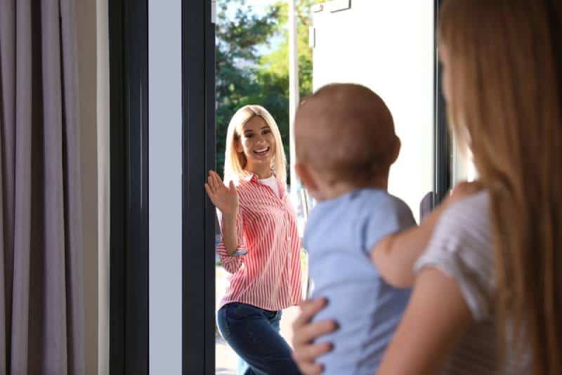 Mom leaving baby with a nanny at home and going outside