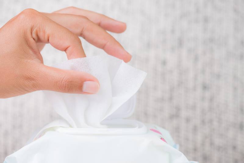 Woman taking a wipe from a pack of baby wipes