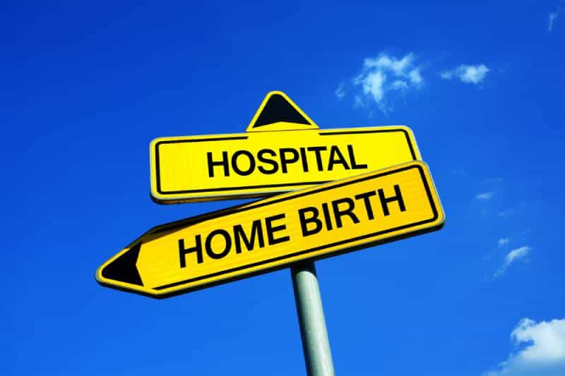 Yellow traffic sign with hospital and home birth written on them