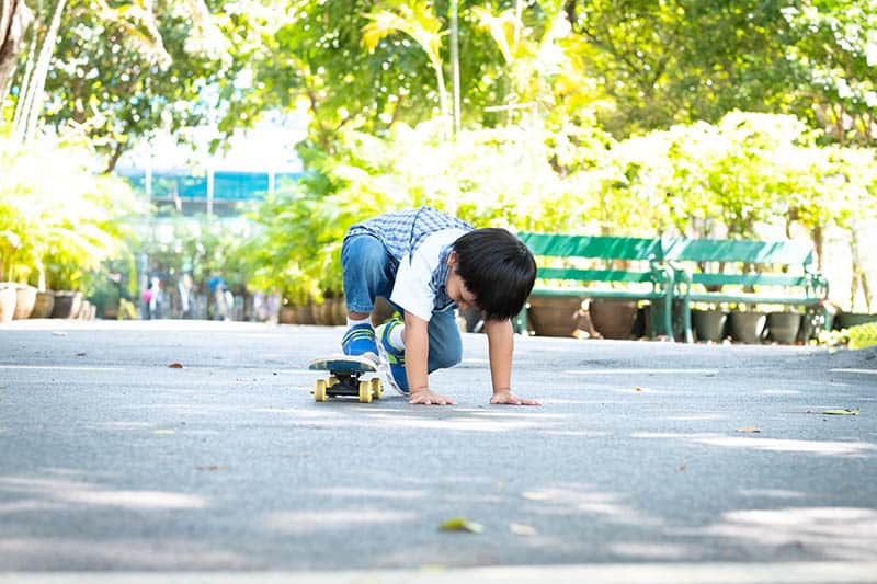 Toddler learning to ride a skateboard