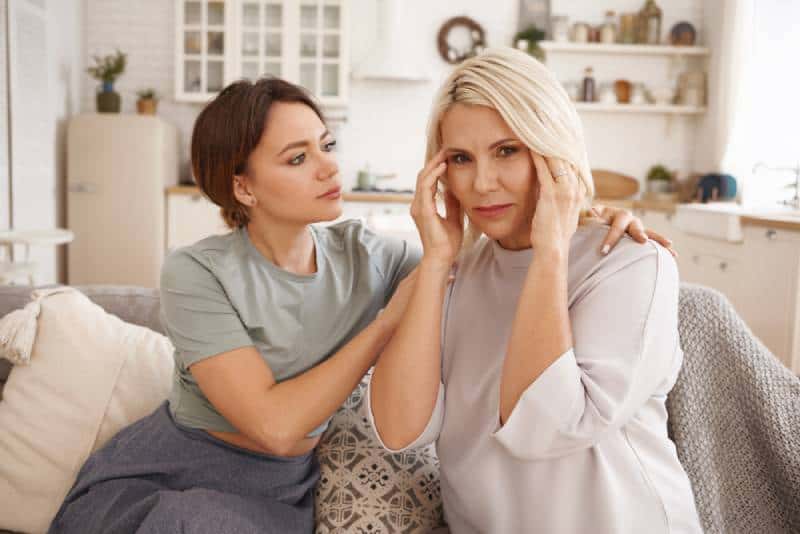 woman comforting middle aged upset mother, worrying about her health
