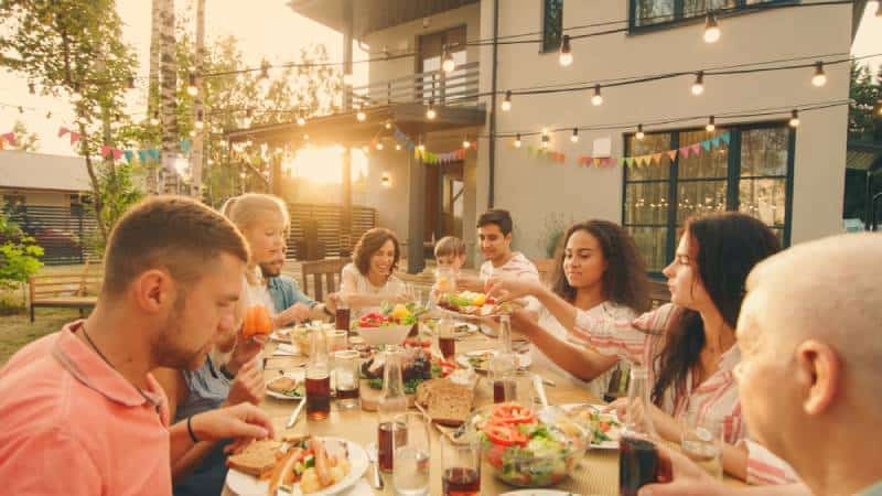 Family eats together outdoors while having fun